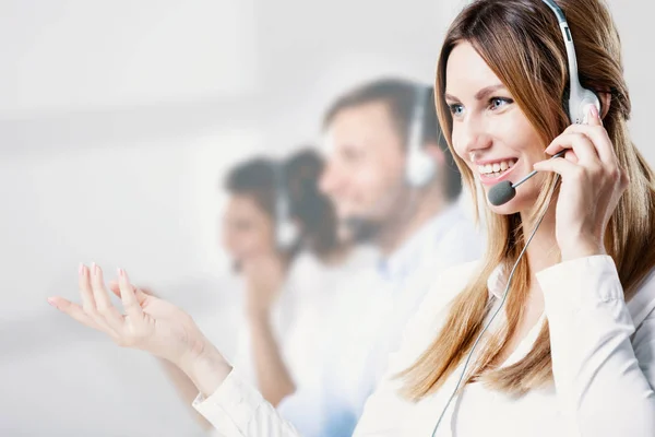 专业的微笑助手与耳机咨询客户在呼叫中心 — 图库照片