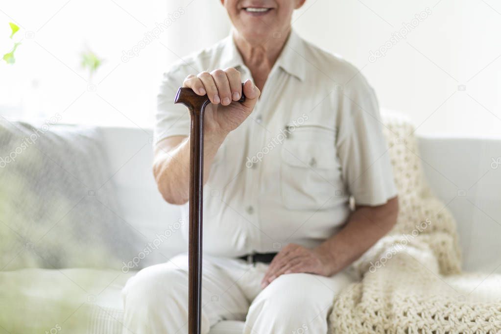 Close-up of smiling and happy senior man with walking stick during 