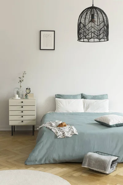 一张双人床 上面有一个绿色和白色的床上用品 站在明亮的卧室内部的木地板上 床旁边的床头柜 真实照片 — 图库照片