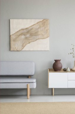 Modern sanat poster oturma odası iç gri Lounge ve beyaz cupobard vazo ile duvara asılı bez ile gerçek fotoğraf