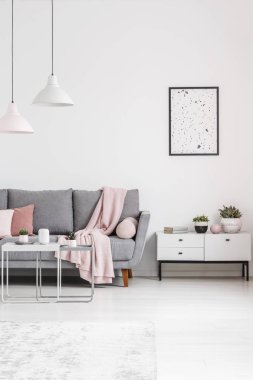 Poster dolap beyaz salon iç lambalar ile gri kanepenin yanındaki yukarıda. Gerçek fotoğraf