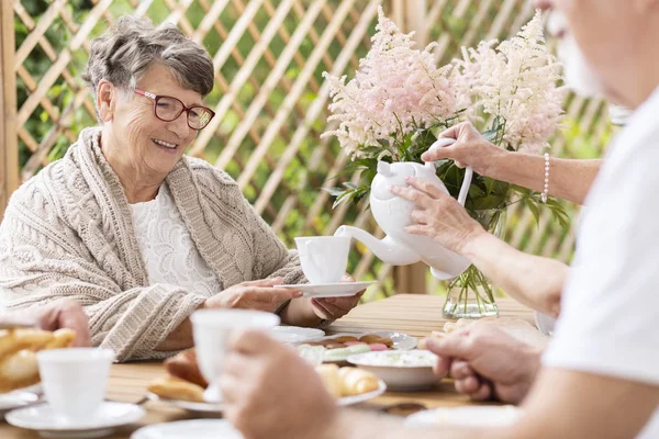 Leende Äldste Kvinna Med Glasögon Som Serveras Ett Samkväm Tabell — Stockfoto