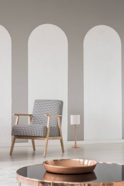 Kemerler bir modern oturma odasında bir retro tekli ile iç ve bir masada bakır plaka yakın çekim. Gerçek fotoğraf