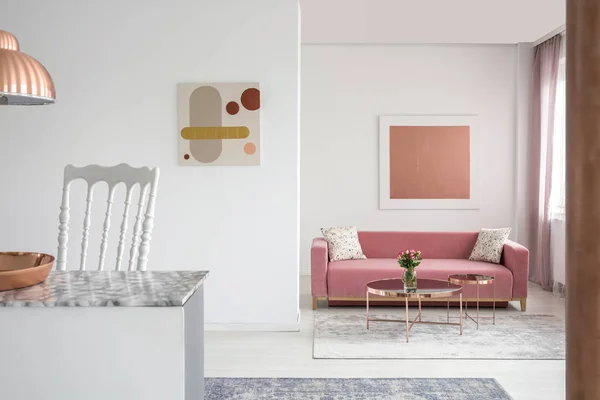 ピンクのソファと銅のコーヒー テーブルを広々 としたリビング ルームのインテリアの絵画の本物の写真 — ストック写真