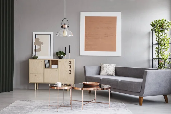 现代沙发和铜表在一个灰色客厅内部与绘画 真实照片 — 图库照片