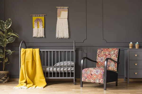 パターン化された肘掛け椅子と工場の子供の寝室のインテリアでベッドの上黄色の毛布 実際の写真 — ストック写真