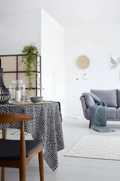 緑の毛布とグレーのソファーで白いアパート インテリアのダイニング テーブル木の椅子 実際の写真 — ストック写真
