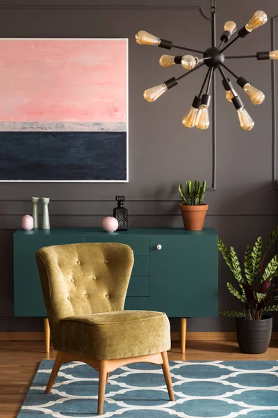 绿色扶手椅上的蓝色地毯在客厅内部与植物和绘画上面的橱柜 真实照片 — 图库照片