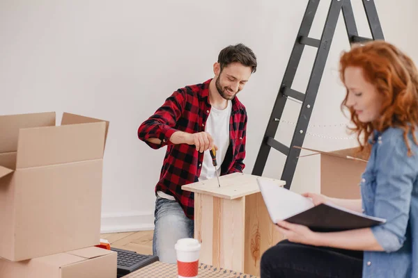 Ler Man Fällbara Möbler Medan Kvinnan Uppackning Grejer Efter Omplacering — Stockfoto