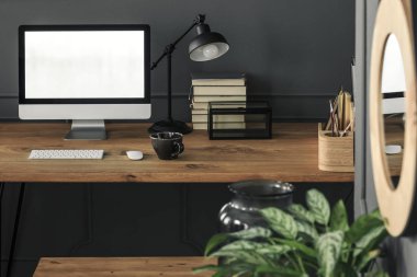 Mockup gri çalışma alanı iç lamba ile ahşap masa masaüstü bilgisayarda. Gerçek bir fotoğraf. Grafiğinizi buraya yerleştirin