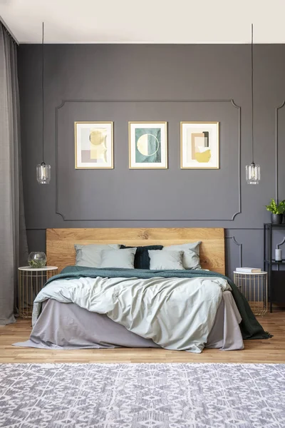 モダンな寝室のインテリアに木製ベッドの上成形と灰色の壁にポスター 実際の写真 — ストック写真