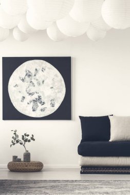 Moon afiş yukarıda bitki üzerinde kabarık siyah kanepe ve gri halı ile beyaz düz iç. Gerçek fotoğraf
