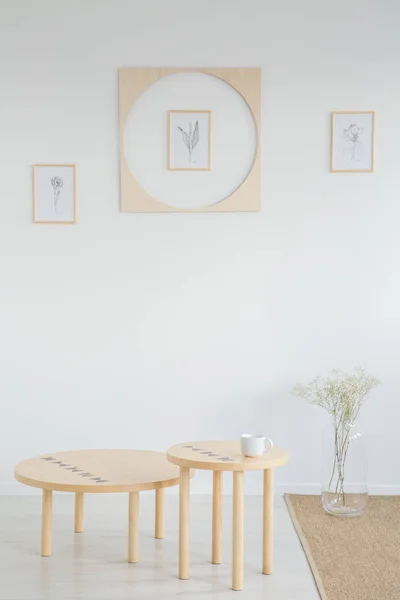 木桌和花在白色极小的客厅内部与海报和地毯 真实照片 — 图库照片