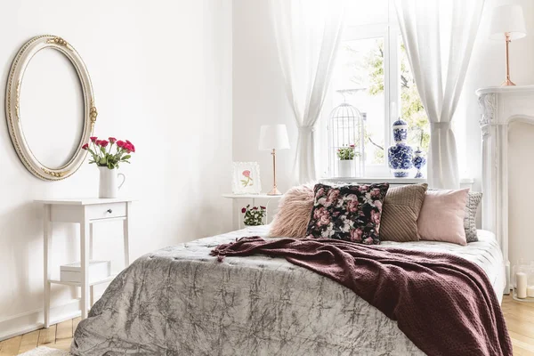 ベッドで甘い寝室のインテリアは銀投球 ブルゴーニュの茶色の毛布および多くのクッションで覆われています 実際の写真 — ストック写真