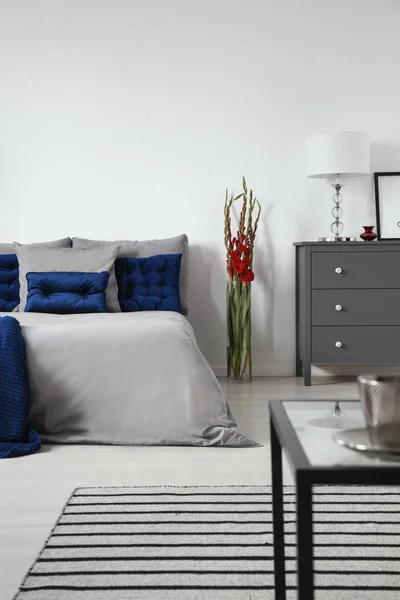 Een Bed Gekleed Grijze Beddengoed Donker Blauwe Kussens Een Moderne — Stockfoto