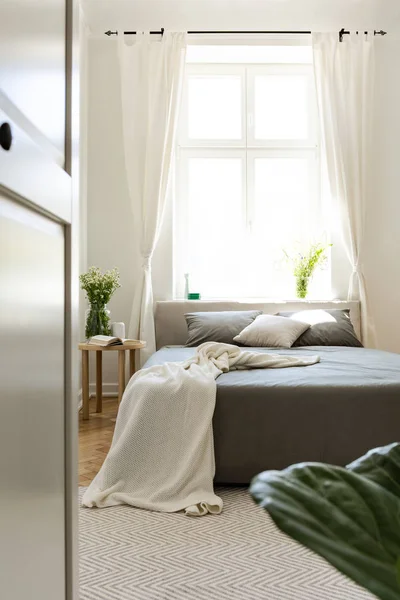 垂直视图成一个阳光明媚的和谐卧室内部与一张床放置在一个明亮的大窗口背景 真实照片 — 图库照片