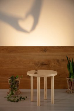 Ahşap masa oturma odası iç duvarda gölge ile sonraki fabrikasında. Gerçek fotoğraf