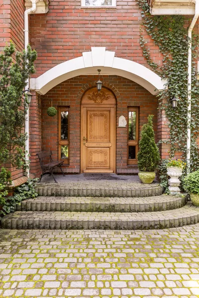 优雅的木制入口门 与常春藤生长在砖墙上的庄园 — 图库照片