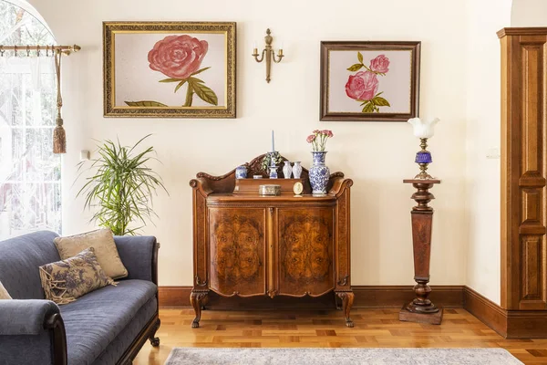 真实照片的古董橱柜与瓷装饰 画玫瑰和蓝色沙发在客厅内部 — 图库照片