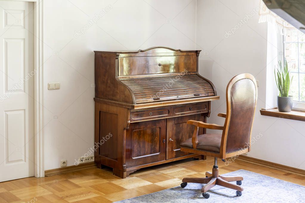 Classic piano and chair on wheels in an antique room interior. Real photo