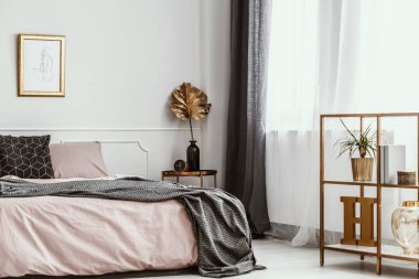 Kadınsı ve sanatsal yatak odası iç altın dekor ve pembe levhalar ile beyaz bir duvar üzerinde çizim siluet çerçeveli