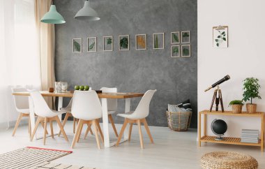Açık alan oturma ve yemek odası iç ahşap mobilya, şık bir dekor ve gri bir duvar bir bitki yaprakları Galeri