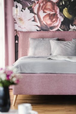 Gri yastık ve yaprak, çiçek duvar kağıdı kadınsı yatak odası iç ile pembe yatak. Gerçek fotoğraf