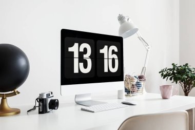 Beyaz masa lambası serbest meslek ile kamera ve masaüstü bilgisayarda dünya ile iç. Gerçek fotoğraf