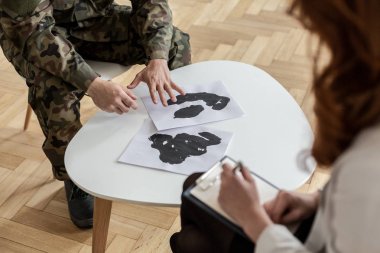 Asker yeşil üniforma ile posterler psikiyatrist ile tedavi sırasında yüksek açı