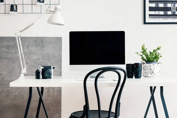 黑色椅子由一张白色书桌与计算机和一盏灯在现代家庭办公室内部为一个专业摄影师自由职业者 真实照片 — 图库照片