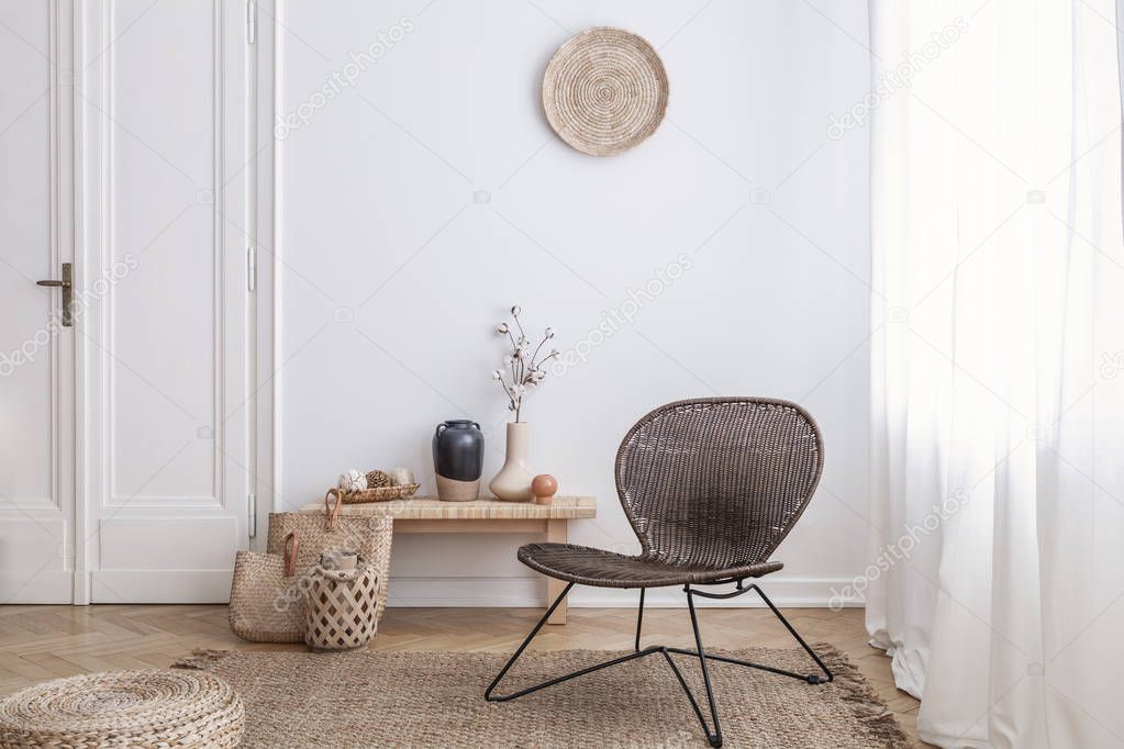 Modern armchair and pouf on brown carpet in white apartment interior with door. Real photo