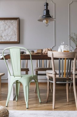 Lamba parlak yemek odası iç duvar posteri ile altında ahşap masa sandalyeler. Gerçek fotoğraf