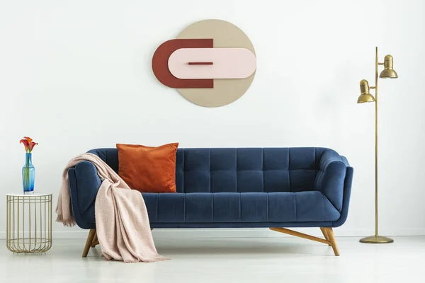 Sofa Biru Dengan Tekstil Nyaman Antara Lampu Lantai Emas Dan — Stok Foto