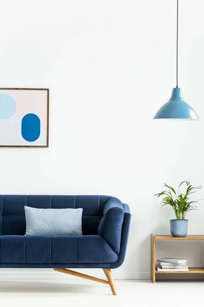 复古碗挂灯和一个婴儿蓝色坐垫在一个黑暗的 优雅的沙发在一个简单的客厅内部与白色的墙壁 真实照片 — 图库照片