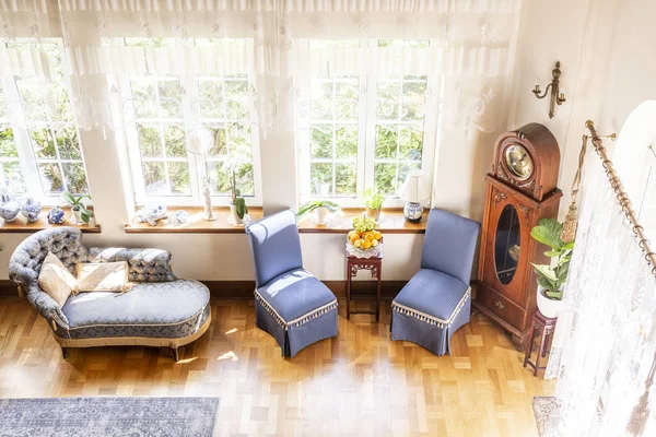 高角度的银色休息室 蓝色椅子和木钟站在窗口旁边的豪华 英语风格的客厅内饰 真实照片 — 图库照片