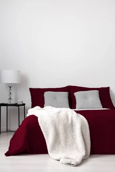 ブルゴーニュのリネン グレーのキルティング クッション バニラの柔らかい毛布に身を包んだベッド ミニマルな寝室のインテリア 白いコピー スペース壁 実際の写真 — ストック写真