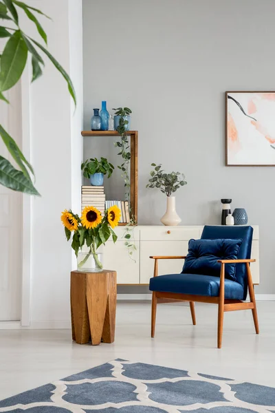 Sonnenblumen Auf Holztisch Neben Blauem Sessel Grauen Interieur Mit Postern — Stockfoto