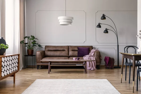 Tisch Vor Ledercouch Mit Pinkfarbener Decke Flachen Interieur Mit Pflanze — Stockfoto