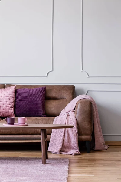 Розовое Одеяло Фиолетовая Подушка Кожаном Диване Светлом Интерьере Гостиной Столом — стоковое фото