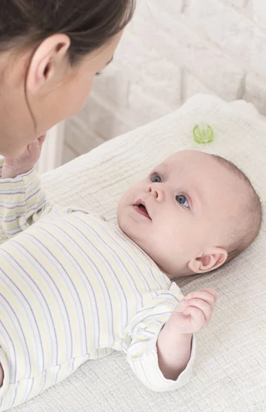 可爱的婴儿在条纹紧身衣看着它的母亲 — 图库照片