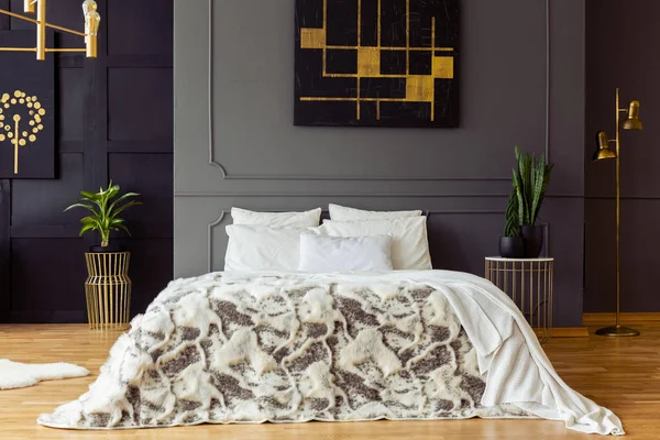 植物と寝室のインテリアに黒とゴールドのポスターで灰色の壁に模様のベッド 実際の写真 — ストック写真