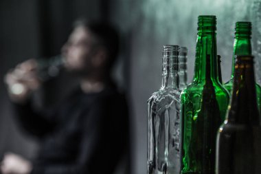 Şişeler ve arka planda alkol bulanık kişi yakın çekim