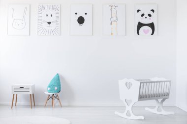 Mavi yastık ve bebeğin yatak odası iç kabin ve duvardaki posterler ile beyaz beşiği. Gerçek fotoğraf