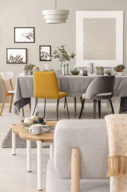 Bir tablonun yanındaki sarı bir sandalye ile SCANDI yemek odası iç gerçek fotoğraf. Bir sandalye Close-up