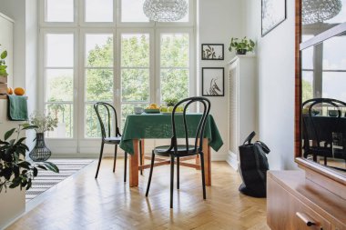 Beyaz bir duvar geniş yemek odası iç cam kapı için balkon ve balıksırtı parke zemin ile botanik posterleri çerçeveli