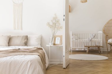 Beyaz metal başucundaki parlak yatak odası iç kapı için yeni doğan bebek odası beşik ile ile yatakta tarafından yerleştirilen dekor ve kahve kupa ile