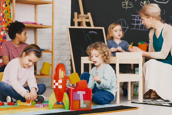 Crianças Multiculturais Brincando Juntas Jardim Infância Com Grande Quadro Negro — Fotografia de Stock