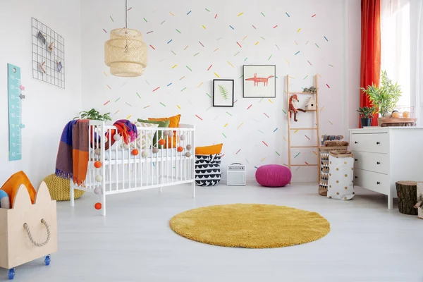 橙色圆形地毯和海报在五颜六色的孩子的房间内饰与摇篮和木制板条箱 真实照片 — 图库照片