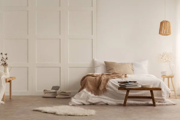 在床前的毛皮和木凳与毯子在白色卧室内饰与灯 真实照片 — 图库照片