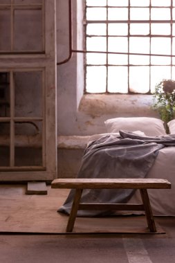 Bir yatak odası iç bir ahşap çerçeve, yatak ve arka penceresinde tabure. Gerçek fotoğraf